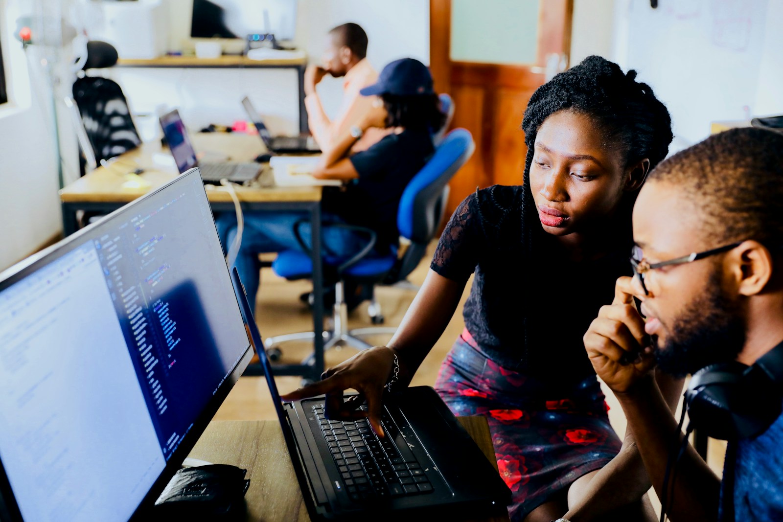 Photo by Desola Lanre-Ologun woman and man sitting in front of monitor
